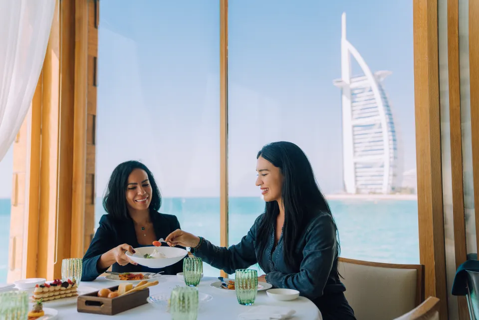 Overwater fine dining set against the Dubai coastline at dusk
